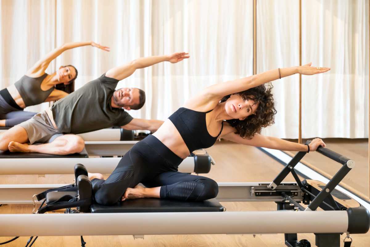 Group of people do the side stretch exercise in a Pilates class.