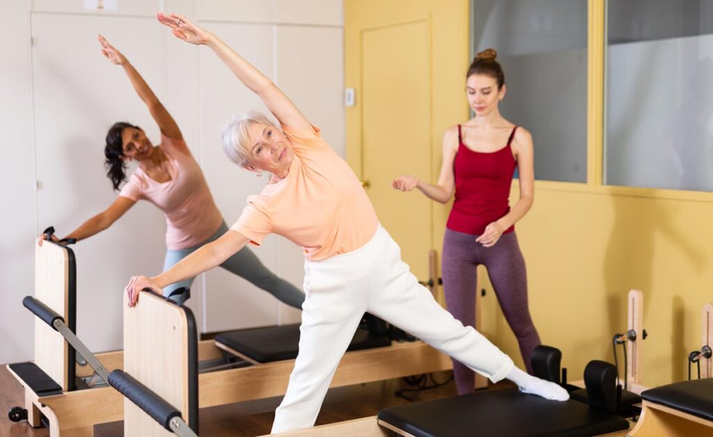 Two women on Pilates reformers going through an arthritis exercise program.