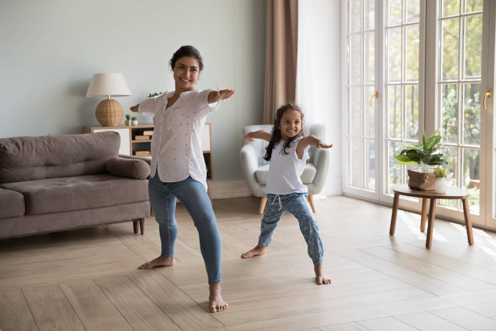 A mother and daughter stretching at home