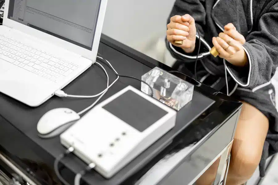 A patient holding on the hand pieces of a BioOptimization therapy device